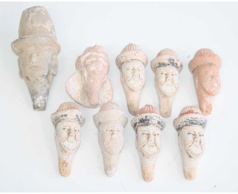 A collection of nine Chinese moulded pottery funeral figure heads, several with remains of polychrome painted finish, Tang / 