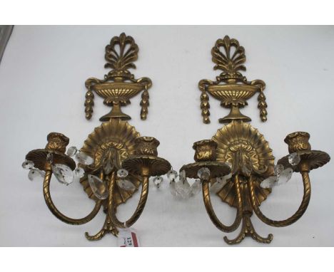 A pair of gilt brass twin sconce wall light fittings surmounted by an urn, height 47cm