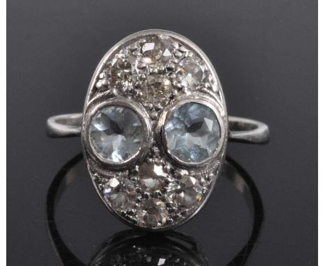 A platinum Art Deco style aquamarine and diamond oval panel cluster ring, featuring two round faceted aquamarine and eight Ol