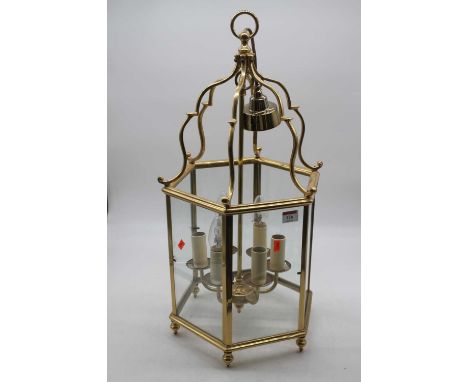 A modern brass framed ceiling light fitting of hexagonal form