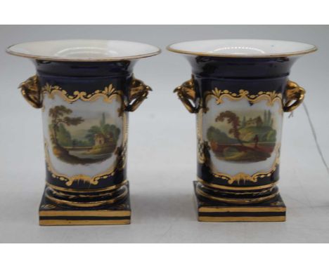 A pair of vases, each on deep blue ground painted with figures within landscapes having gilt metal handles on further gilt an