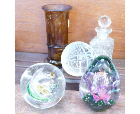 Three glass paperweights including a Waterford globe of the world, a small glass decanter and a glass vase