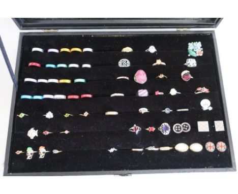 Modern glazed top display case containing a selection of various costume style dress rings, cufflinks etc 