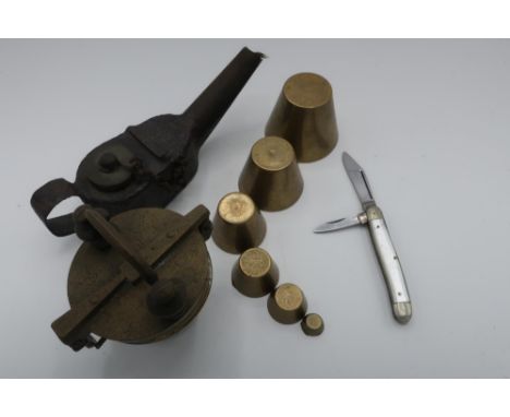 Cast metal oil burning lamp, set of Oriental style graduating opium weights, and a twin bladed pocket knife (3) 