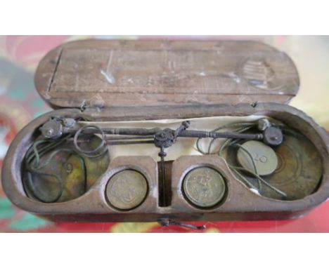 Set of early19th century travelling scales, steel balance with brass pans and ten various weights, oval chip carved mahogany 