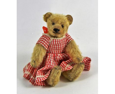 A small Steiff blonde mohair teddy bear, 1920s, straw stuffed with black and brown glass eyes, stitched nose, mouth and claws