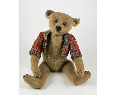 A Steiff blonde mohair Teddy Bear, circa 1909, straw stuffed with black button eyes, black stitched nose, mouth and claws, sw