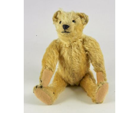 A Strunz blonde mohair Teddy bear, German circa 1908, straw stuffed bear with black boot button eyes (replaced), horizontally