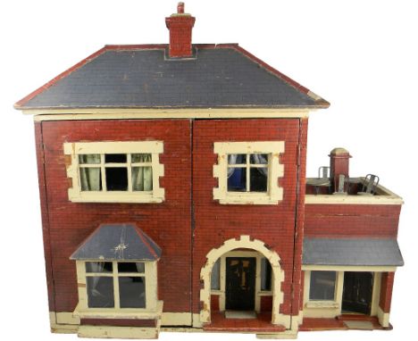 A wooden painted Dolls House with contents, 1930s, the façade and sides painted in red brick effect, arched porch with hinged