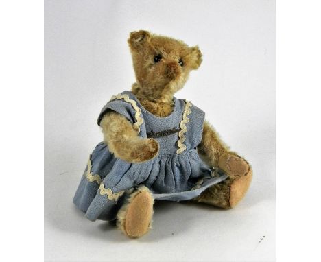 A Steiff blonde mohair Teddy Bear, circa 1909, straw stuffed with black boot button eyes, brown stitched nose, mouth and claw