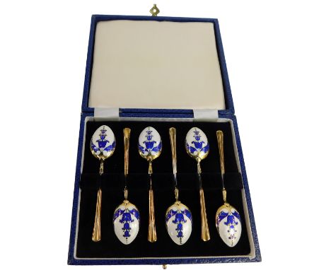 A set of six Elizabeth II silver gilt and enamel coffee spoons, each bowl with blue floral enamel decoration against a white 