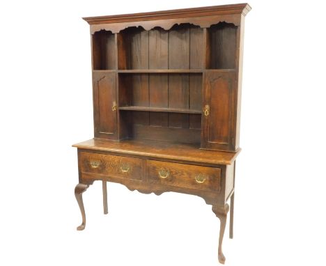 An 18thC and later oak dresser, the top with a moulded edge above an arrangement of five shelves with two panelled cupboards,