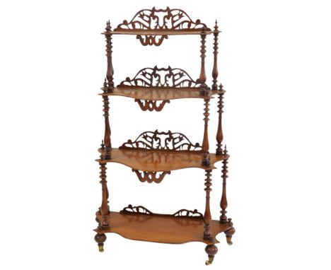 A Victorian mahogany four-tier waterfall whatnot, each shaped shelf with a raised pierced back, united by turned columns, on 