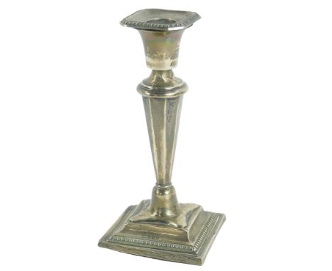 A George V loaded silver candlestick, with a fluted column, raised on an outswept square base, Birmingham 1916, 5.75oz all in