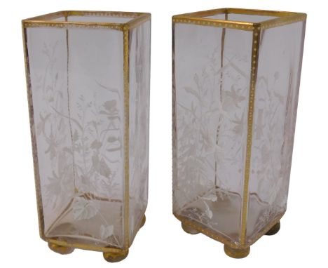 A pair of Victorian clear glass vases, of rectangular form, decorated in white enamel with flowers, with a gilt border, on fo