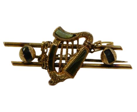 A yellow metal bar brooch, set with jade, decorated on a harp, 5.3g, 2cm high, 4.5cm wide.