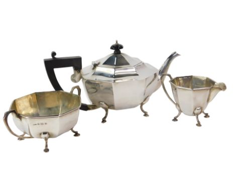 A George VI silver three-piece tea service, of octagonal form, raised on cabriole legs with hoof feet, comprising teapot, twi