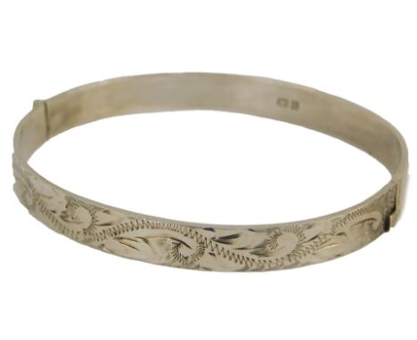 A silver bangle, with engraved foliate decoration, on a snap clasp, 0.52oz. 