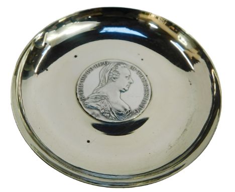 A white metal trinket dish, inset with a Maria Theresa thaler, dated 1780, 2.55oz, 10cm diameter. 