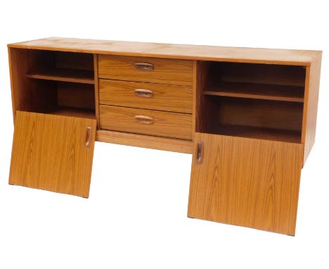 A 1970s Schreiber teak sideboard, the rectangular top above three central drawers, flanked by two open shelves on turned cyli