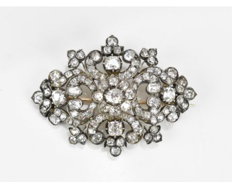 An Edwardian white metal diamond encrusted brooch, set with various sized old mine cut diamonds, the central freeform stone i