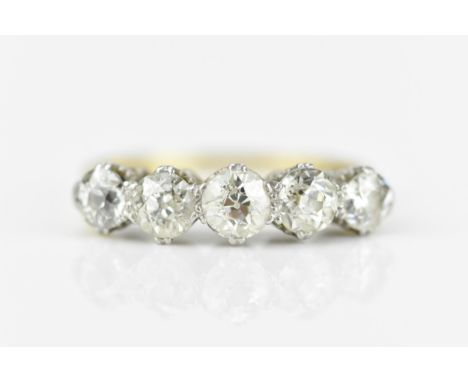 An 18ct gold and five stone diamond ring, set with old cut diamonds in double claw setting, the central stone approx 0.45 car