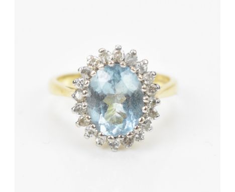 An 18ct yellow gold, diamond and aquamarine dress ring, set with central oval faceted cut aquamarine stone in a halo of twent