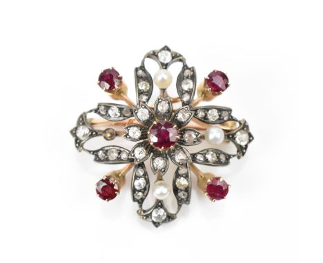 An Edwardian diamond and ruby encrusted brooch, set in rose metal and white metal, forming a stylised cross with central flor