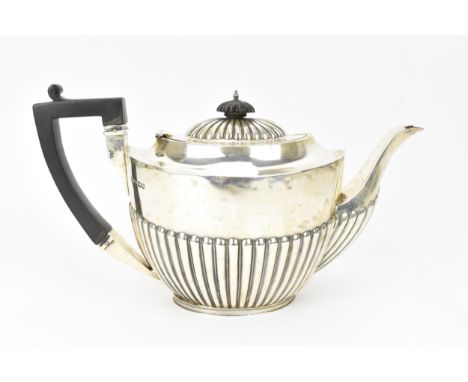 A late Victorian silver teapot by James Deakin &amp; Sons, Sheffield 1900, of oval form with part fluting, ebonised handle an