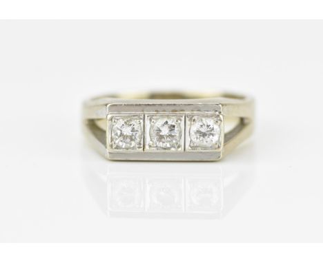 An 18ct white gold and three stone diamond dress ring, set with three same-sized brilliant cut stones in individual four claw