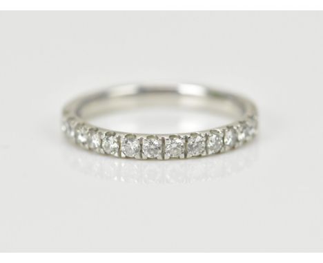 A platinum and diamond half eternity band, set with thirteen pave set brilliant cut diamonds, hallmarked to shank 950, size M