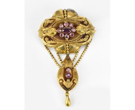 A Victorian Etruscan revival yellow metal and amethyst brooch, with central floral cluster, the brooch o lobbed form with bea