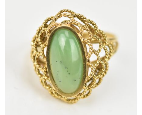 A yellow gold and jade dress ring, the central oval cabochon stone in a pierced rope twist setting, size Q, 5.9 grams 