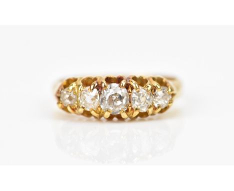 A yellow metal and five stone diamond ring, set with graduated old mine cut diamonds, the central one approx 0.25 carat, size