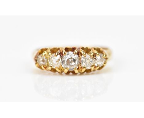 A yellow metal and five stone diamond ring, set with graduated old mine cut diamonds, the central one approx 0.25 carat, size