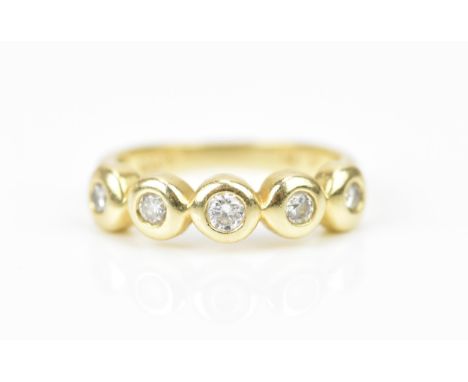 A 14 ct yellow gold and diamond five stone ring, set with five bezel set graduated brilliant cut diamonds, shank stamped 585,