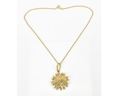 An Edwardian yellow metal, diamond and seed pearl starburst pendant on a 9ct gold chain, the pendant with central old cut dia