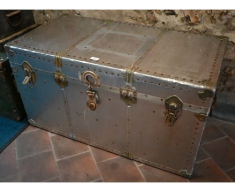 A vintage rivetted aluminium flight trunk with leather handles and fabric lined interior 