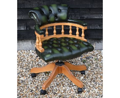 A modern green leather button back revolving captain's chair 
