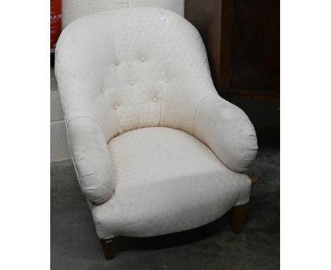 A low button back bedroom armchair with cream upholstery 