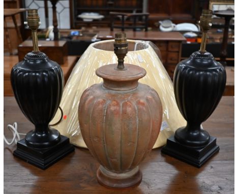 A pair of black ceramic lamp bases in the form of classical urns by Wedgwood for Jane Churchill, 40 cm high to/w a terracotta