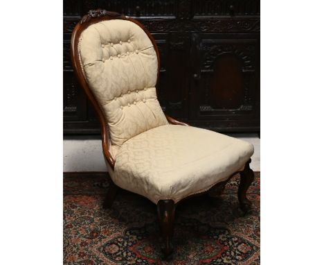 A Victorian mahogany floral carved nursing chair with button back damask upholstery 