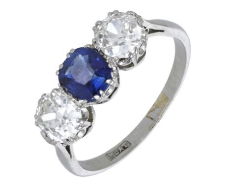 A sapphire and diamond three stone ring, the central round sapphire flanked by two old-cut diamonds, claw set, with platinum 