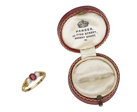 A mid 19th century ruby and pearl three stone ring, the oval-cut ruby set between two seed pearls, to scrollwork shoulders, c