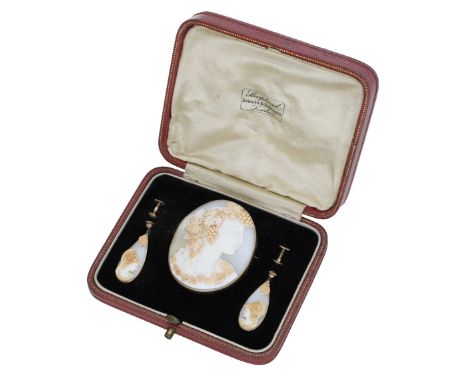 A 19th century shell cameo brooch and pair of earrings, the oval brooch carved to depict a bacchante with fruiting vines to h