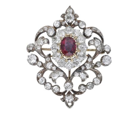 A ruby and diamond brooch, circa 1890, the openwork scrolling cartouche set centrally with an oval-cut ruby, the surround set