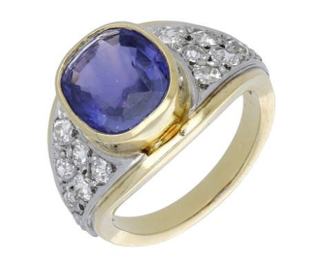 A sapphire and diamond dress ring, the cushion-shaped purple sapphire in a rubover setting between bicoloured tapering should