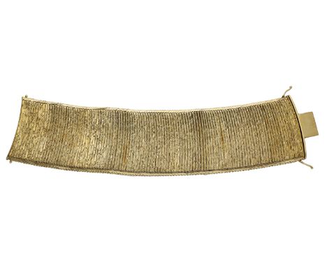 A gold bracelet, circa 1979, the wide strap formed of overlapping bars with a textured finish, London import mark for 9ct gol