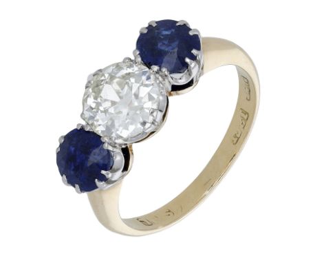 A sapphire and diamond three stone ring, set with an old brilliant-cut diamond set between two oval-shaped sapphires, stamped