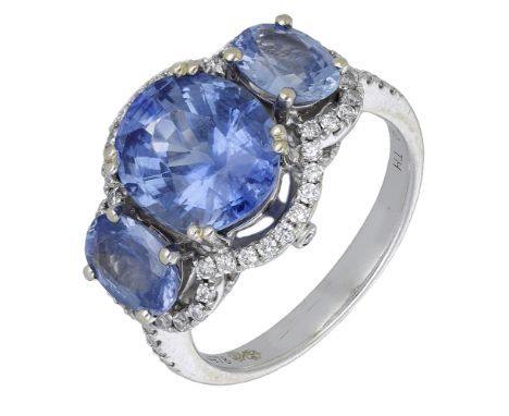 A sapphire three stone ring, the central oval mixed-cut sapphire with similarly-cut sapphires to either side, within an outer